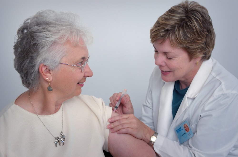 Clinician giving a vaccination to a senior patient at Ezzeddine Primary Care in Rancho Cucamonga